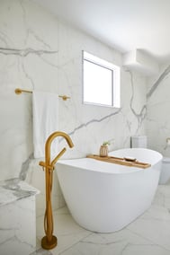 Bathroom renovation with freestanding tub, brass faucets, and large format tile in Ontario
