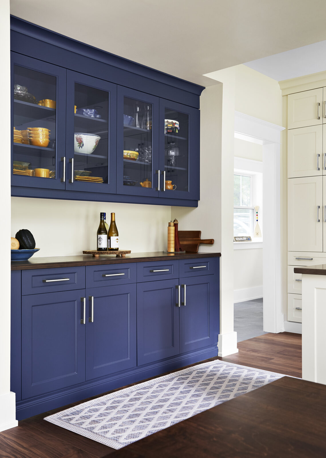 Custom bar area with navy blue cabinets with glass upper cabinets in Markham