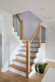 Front view of main floor staircase in Markham home renovation with black posts