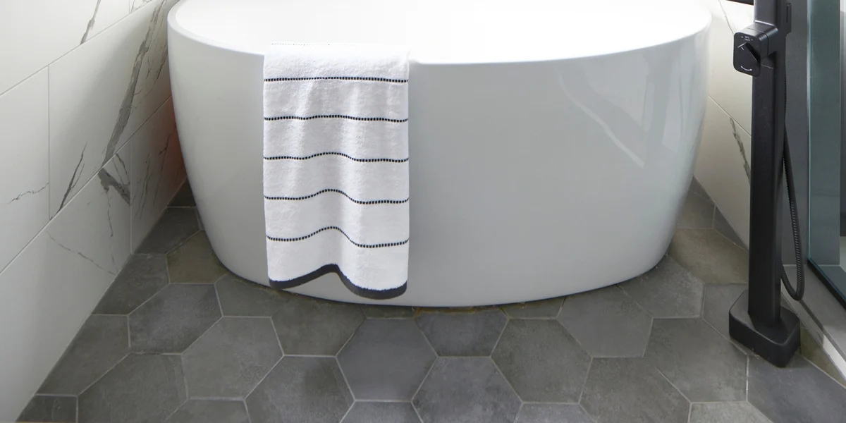 Hexagonal grey bathroom tile with freestanding porcelain tub-1