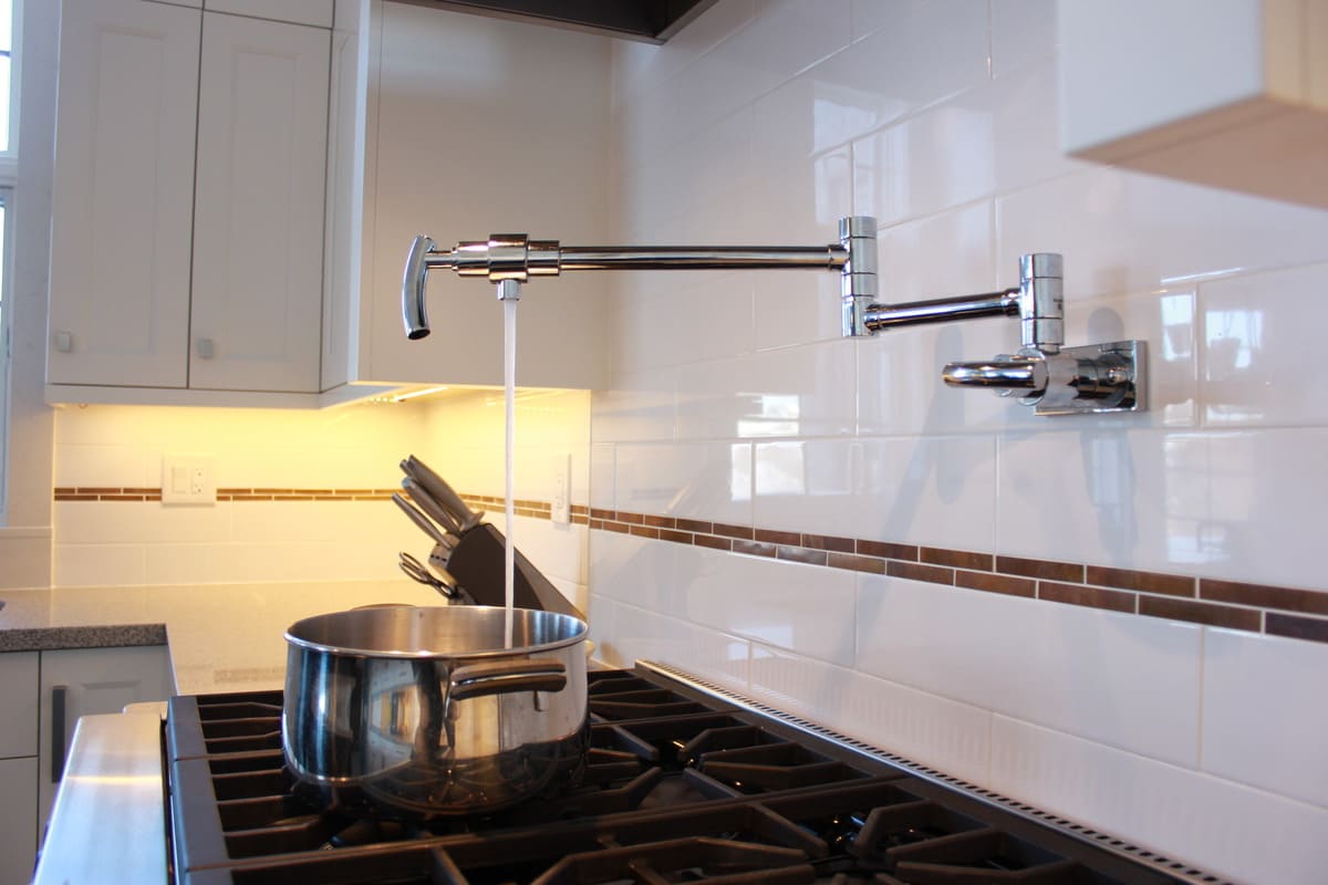 Pot filler in Markham kitchen renovation with copper tile accent along subway tile backsplash