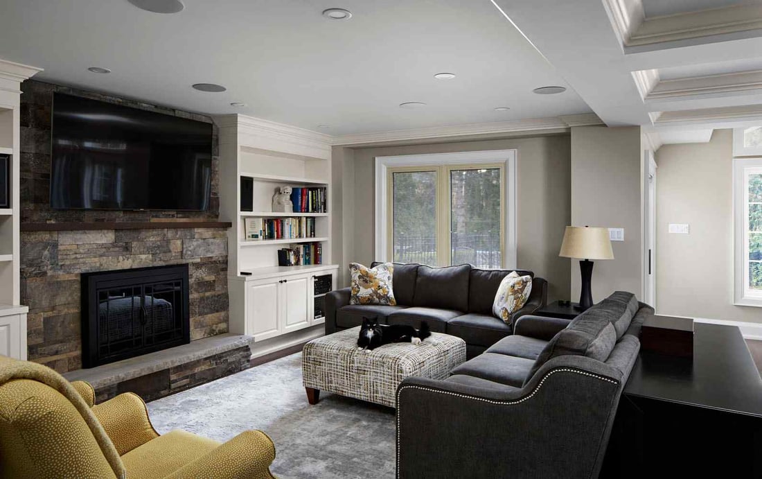 Modern living room renovation with recessed lighting and custom stone fireplace
