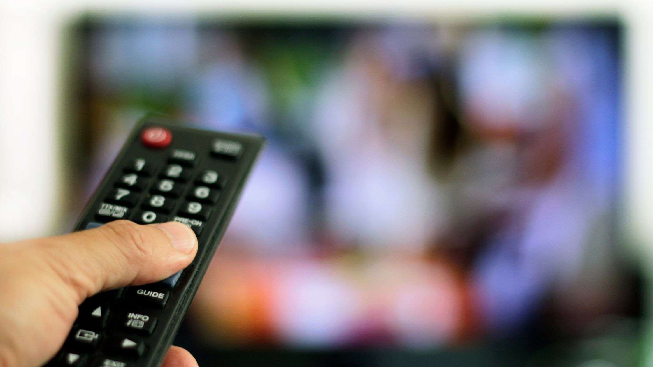 Person Changing Channel of Television on in Background