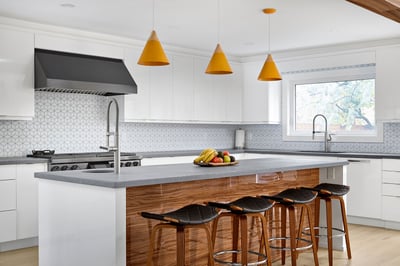beautiful contemporary kitchen renovation with yellow hanging lights above massive kitchen island in markham
