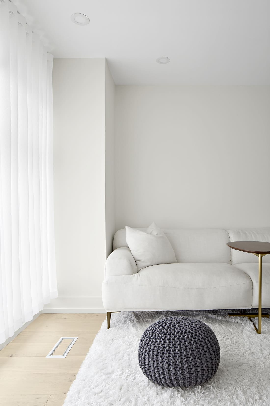 Couch in primary suite by window with natural light