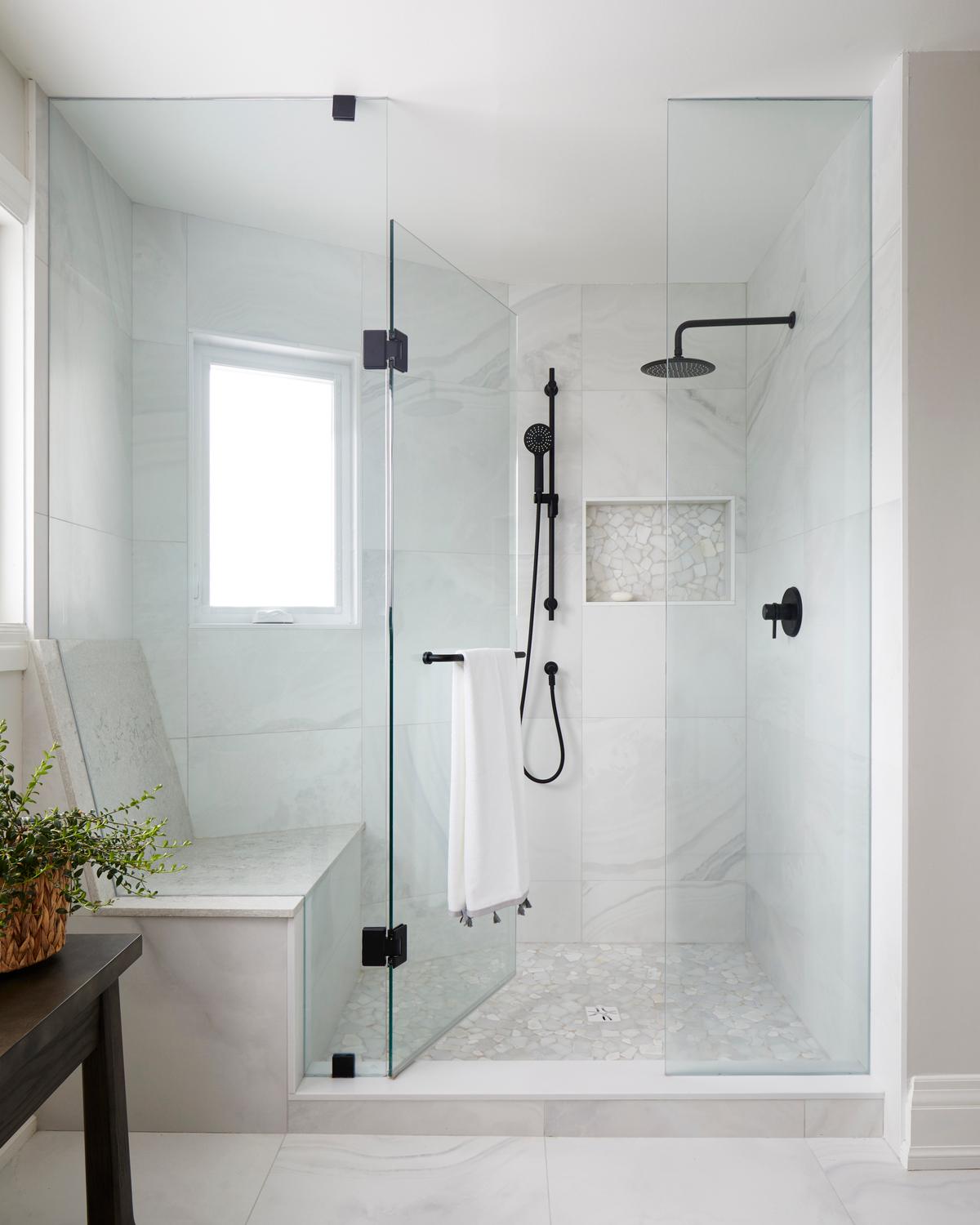 Modern primary ensuite shower with built-in seating and towel bar