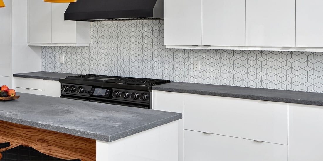 Mosaic backsplash tile in kitchen with white flat panel cabinets
