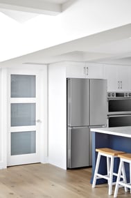 paneled door with glass next to white modern kitchen in markham