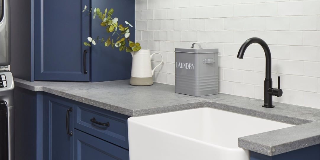 Stone countertop in luxury laundry renovation with blue cabinets