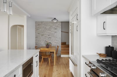 white modern kitchen renovation with stone accent wall and dinner table in markham