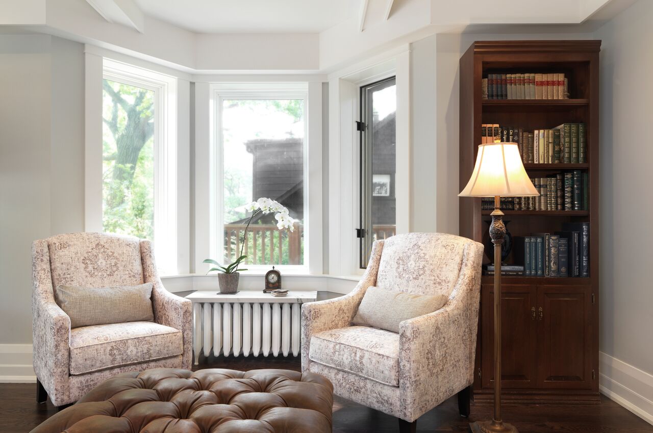 transitional living room with coffered ceiling and two chairs