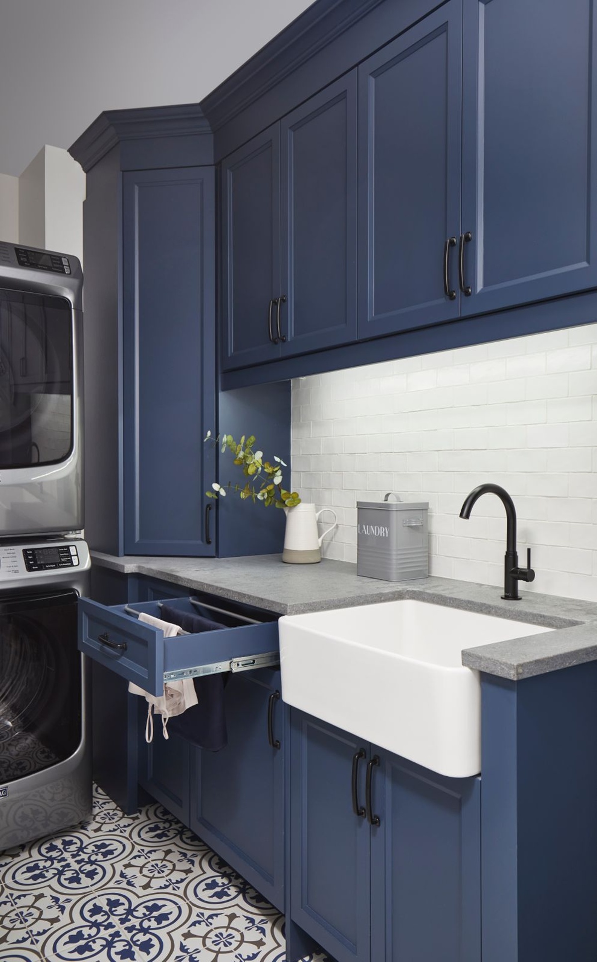 Navy blue cabinets with open drawer towel drying in modern laundry room in Markham, Ontario