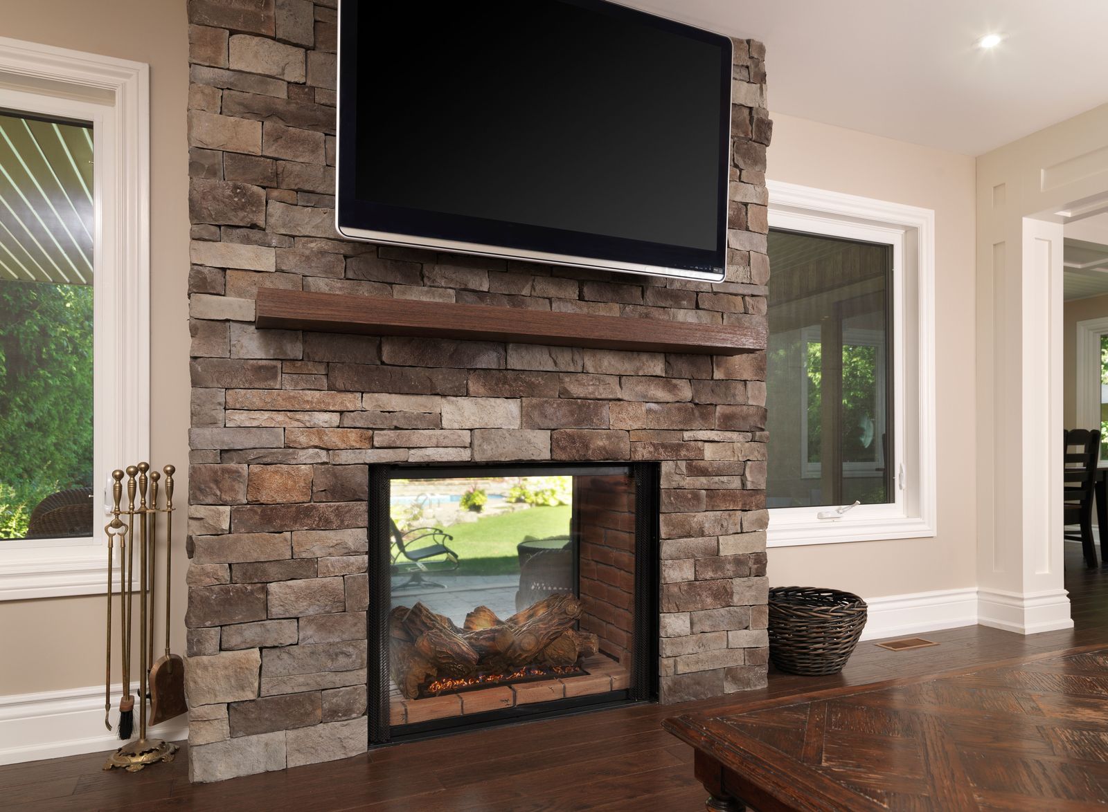 two way fireplace with stone walling and floating tv in markham home renovation